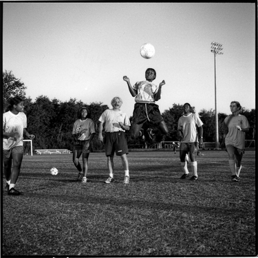 Photograph of The Queen Bees at Patriot's Point soccer team. Photograph depicts Kendra Coaxum heading a soccer ball.